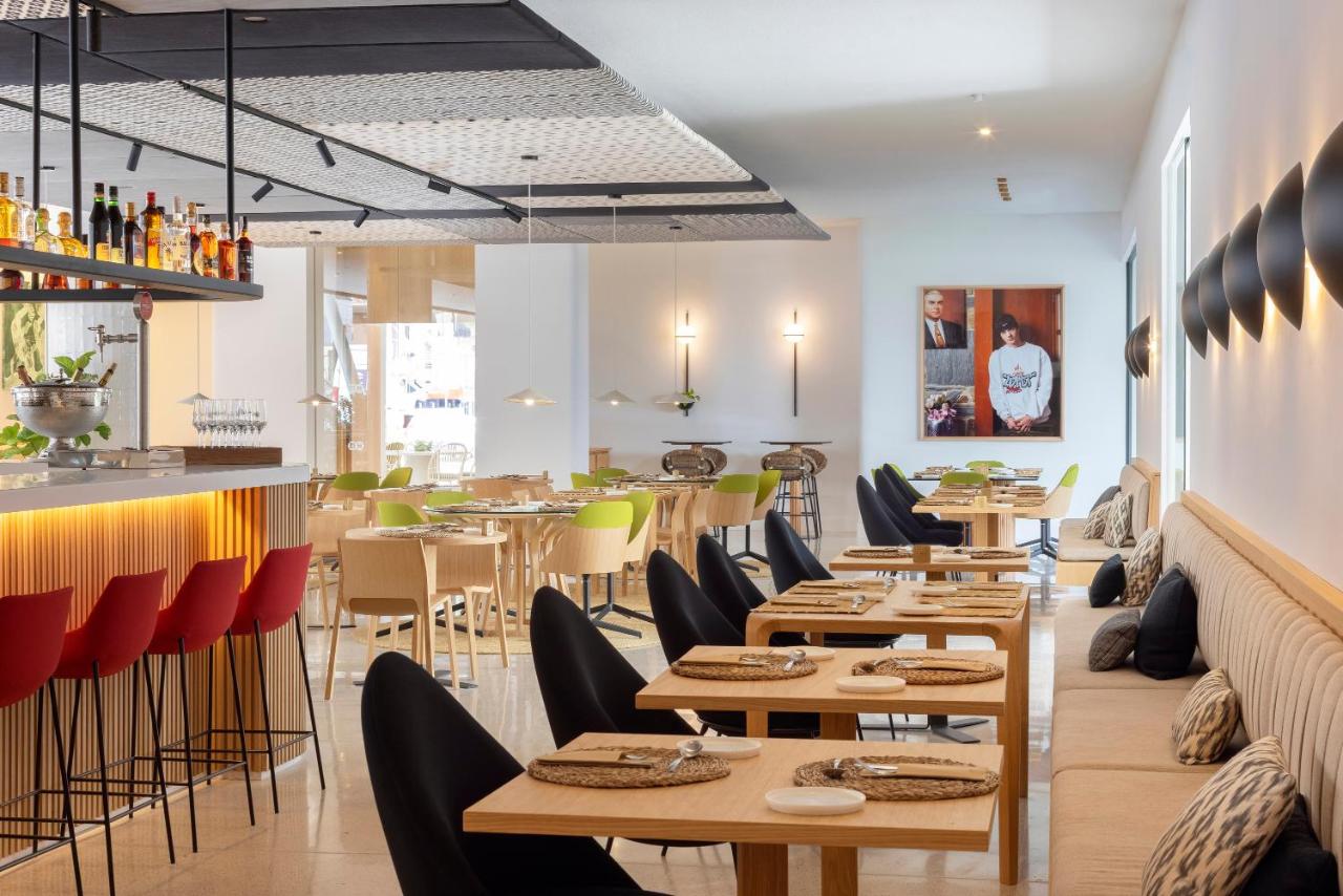 een restaurant met houten tafels en stoelen en een bar bij HM Palma Blanc in Palma de Mallorca