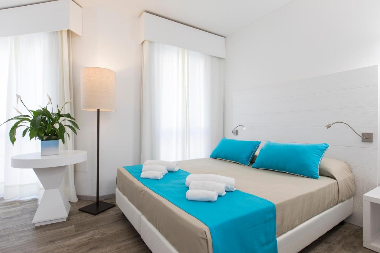 een slaapkamer met een groot bed met blauwe kussens bij Lu' Hotel Maladroxia in SantʼAntìoco