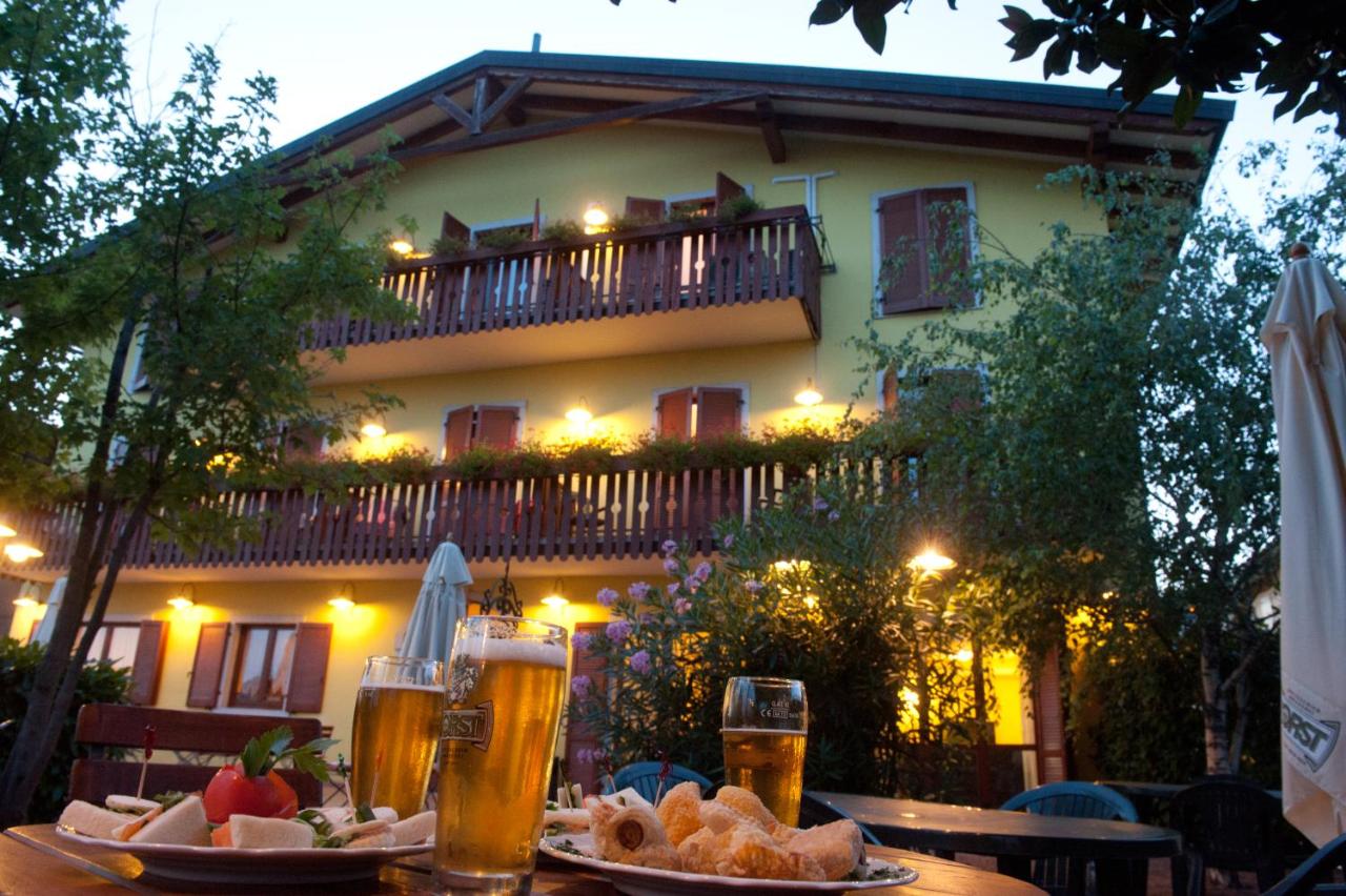 een tafel met borden vol eten en glazen bier bij Hotel Romantic in Cavaion Veronese