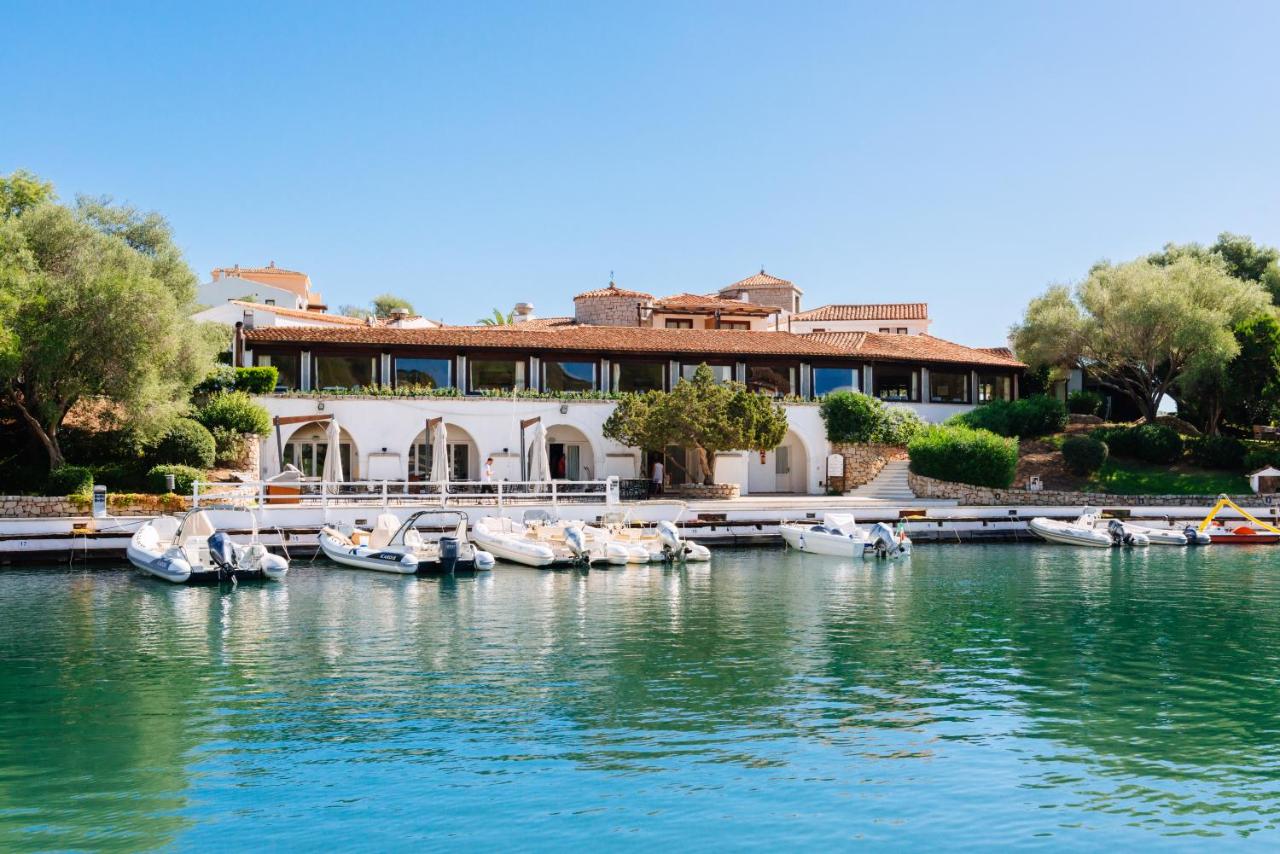 een huis aan het water met aangemeerde boten bij Hotel Palumbalza Porto Rotondo in Porto Rotondo