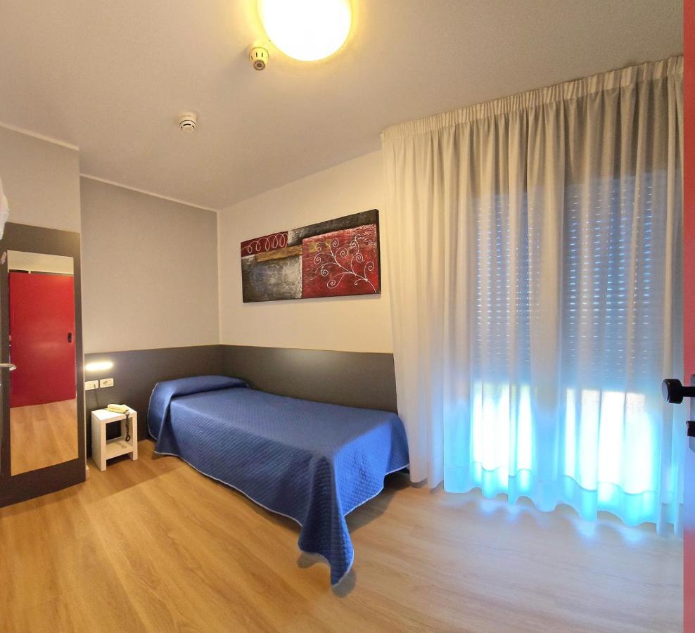 een slaapkamer met een blauw bed en een raam bij Hotel Panorama in Lido di Jesolo