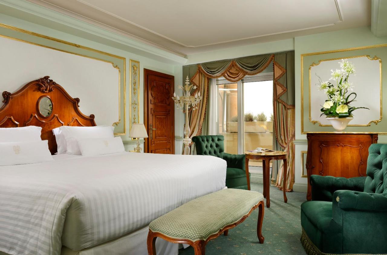 een slaapkamer met een bed, een stoel en een tafel bij Parco dei Principi Grand Hotel & SPA Roma - Preferred Hotels & Re