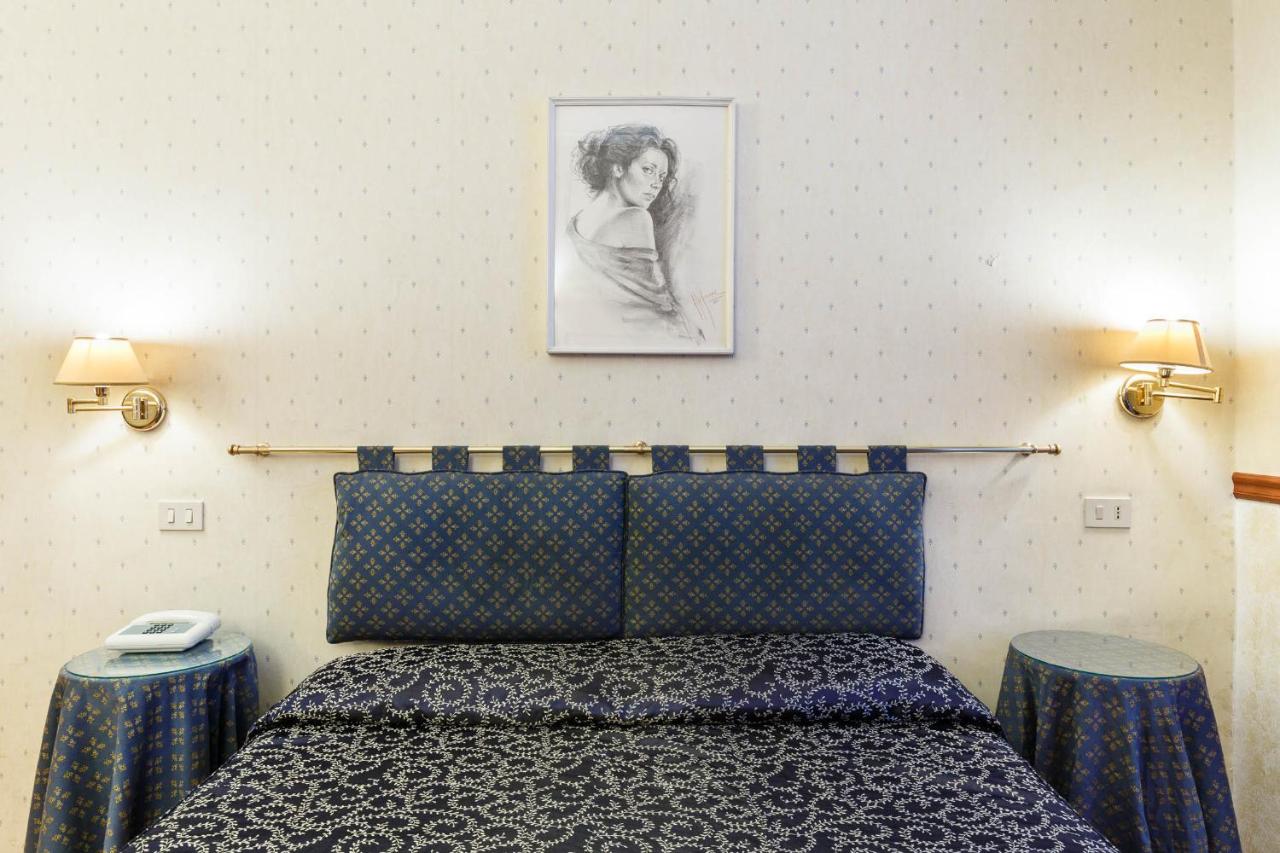 een slaapkamer met een bed, twee nachtkastjes en een schilderij aan de muur bij Hotel Paris in Rome
