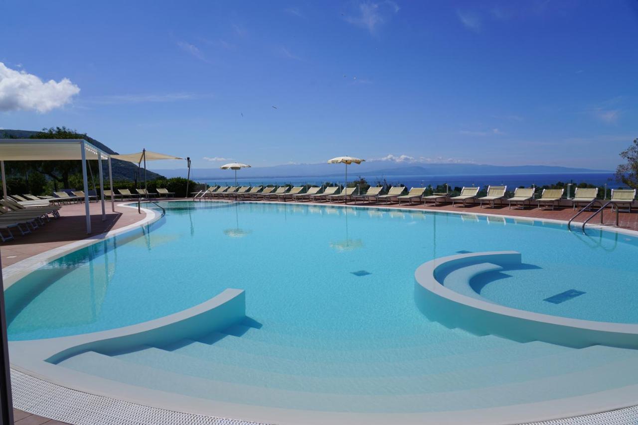 een groot zwembad met ligstoelen en blauw water bij LUZIA AGRIRESORT - Piscina Panoramica e vista Mare a Capo Vaticano i
