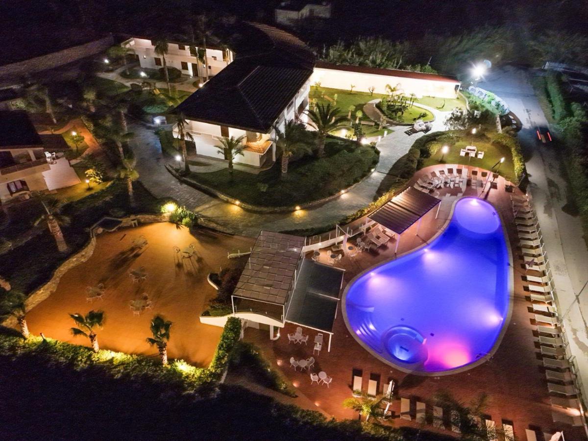 Een bovenaanzicht van een zwembad 's nachts. bij LUZIA AGRIRESORT - Piscina Panoramica e vista Mare a Capo Vaticano in C