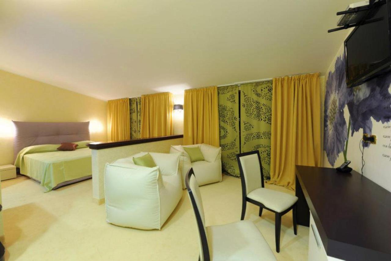 een hotelkamer met een bed, een bank en een stoel bij Grand Hotel Paradiso in Catanzaro Lido