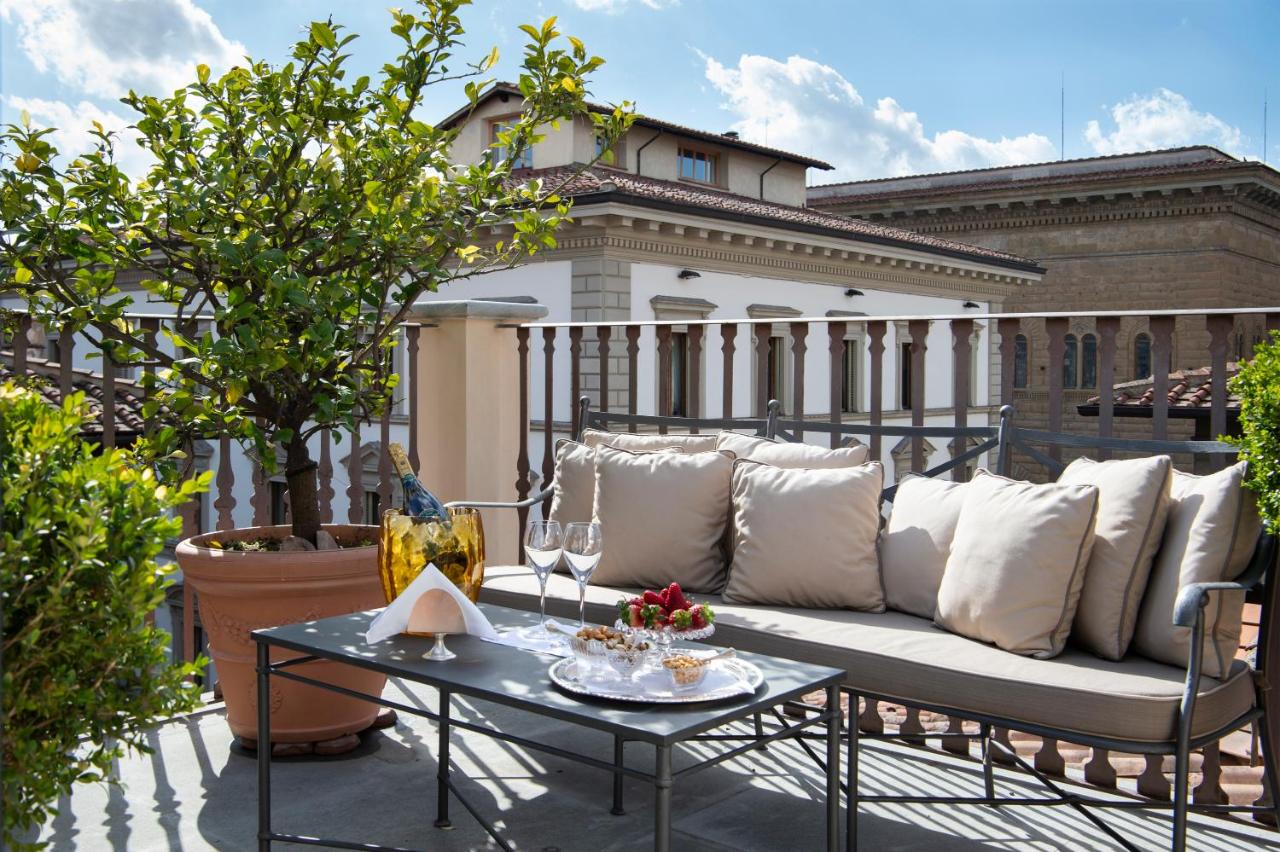 een bank en een tafel op een balkon bij Palazzo Vecchietti - Residenza D'Epoca in Florence