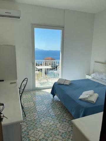 een slaapkamer met een bed en uitzicht op de oceaan bij Hotel Villa Pina Antico Francischiello in Massa Lubrense