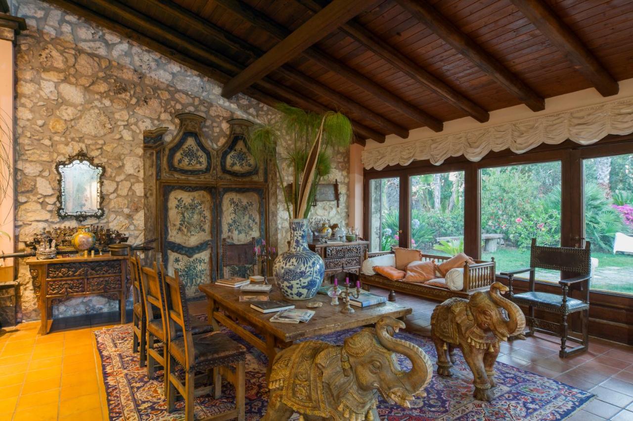 een woonkamer met een tafel en een bank bij Villa Dei Papiri Fonte Ciane in Siracusa