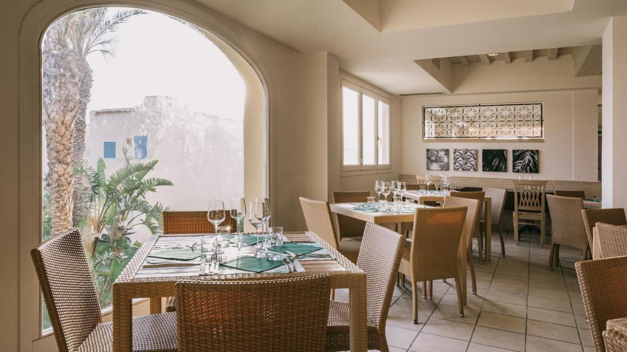 een restaurant met tafels en stoelen en een groot raam bij Mangia's Favignana Resort in Favignana