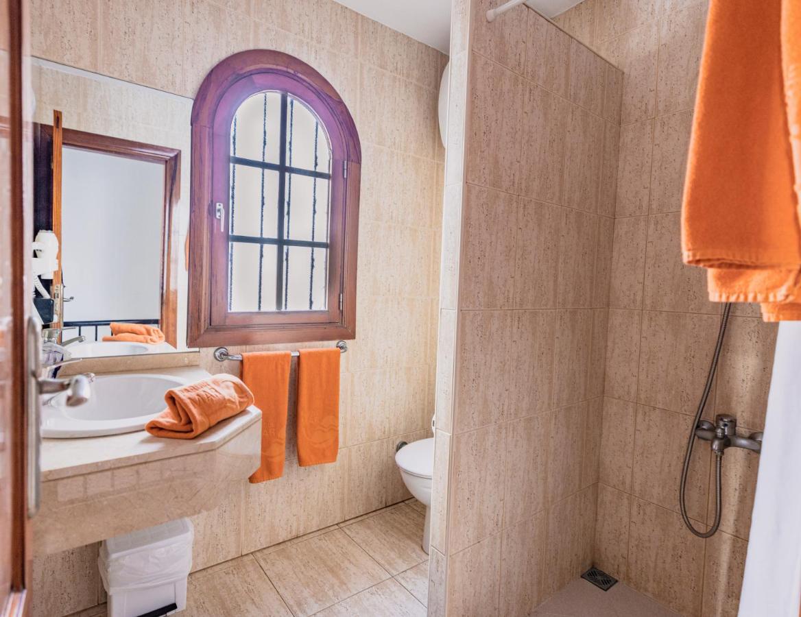 een badkamer met een wastafel, een toilet en een raam bij Parquemar in Playa del Inglés