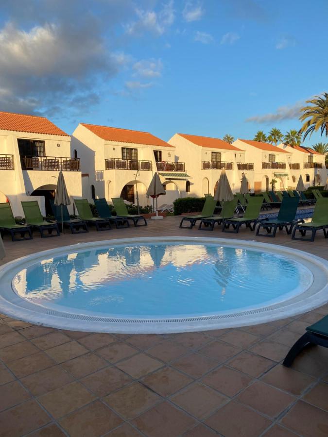 een zwembad met ligstoelen en een resort bij Parquemar in Playa del Inglés