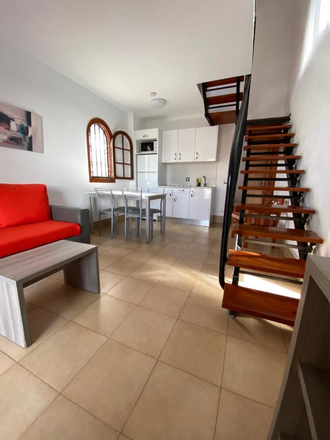 een woonkamer met een rode bank en een keuken bij Parquemar in Playa del Inglés