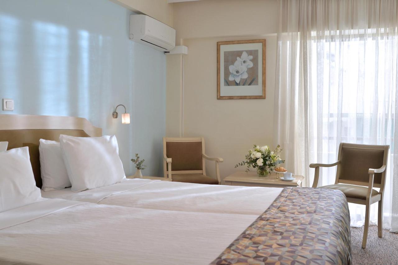 een hotelkamer met een bed en twee stoelen bij Airotel Parthenon in Athene