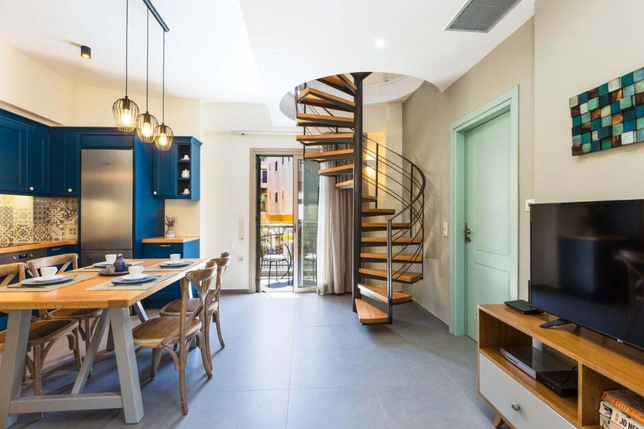 een eetkamer met een tafel en een wenteltrap bij Philoxenia Residences in Panormos Rethymno
