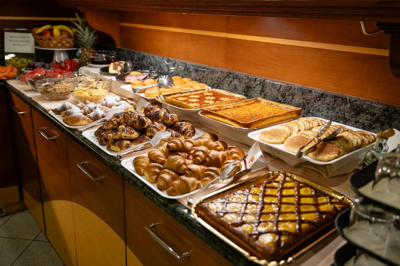 een buffet met veel verschillende soorten brood en gebak bij Aparthotel Pineda in Bibione
