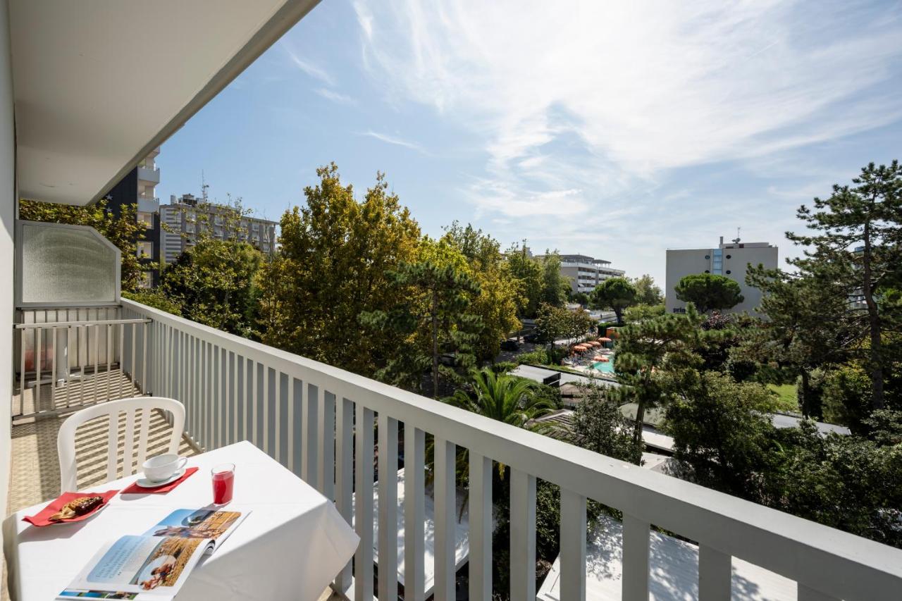 een balkon met een tafel en uitzicht op de stad bij Aparthotel Pineda in Bibione