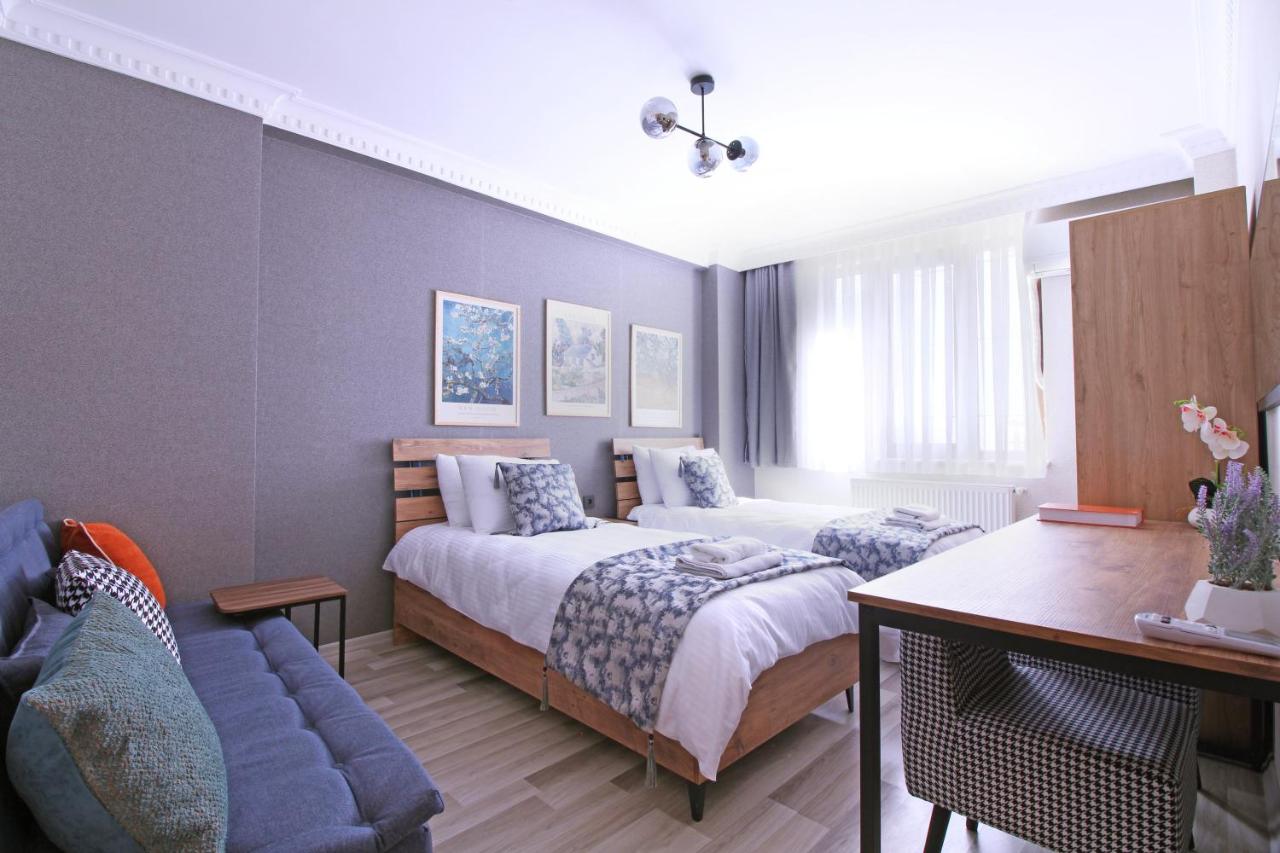 een slaapkamer met twee bedden, een tafel en een bank bij Excellent Apartments Pierre Loti in Istanbul