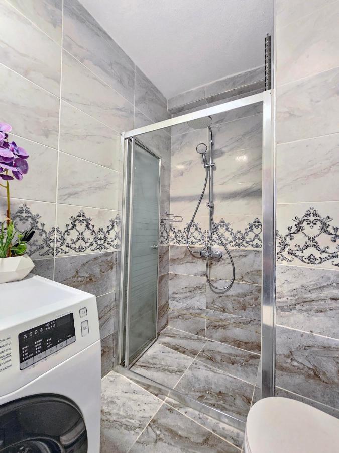 een badkamer met een douche en een wasmachine bij Excellent Apartments Pierre Loti in Istanbul