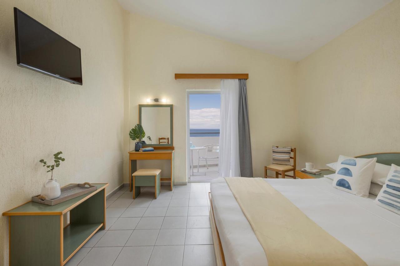 een hotelkamer met een bed en uitzicht op de oceaan bij Porto Skala Village Hotel in Skála Kefalonias