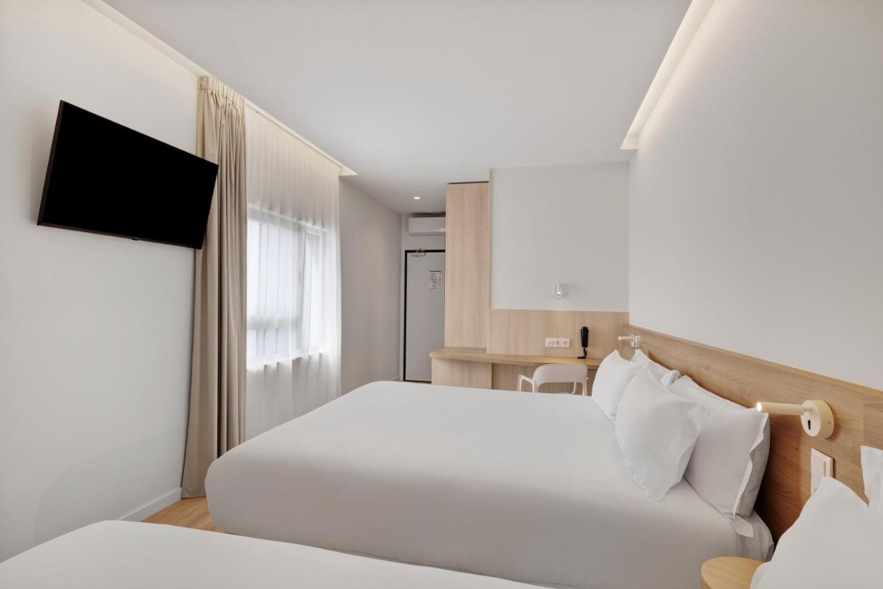 een hotelkamer met twee bedden en een tv bij B&B HOTEL Viana do Castelo in Viana do Castelo