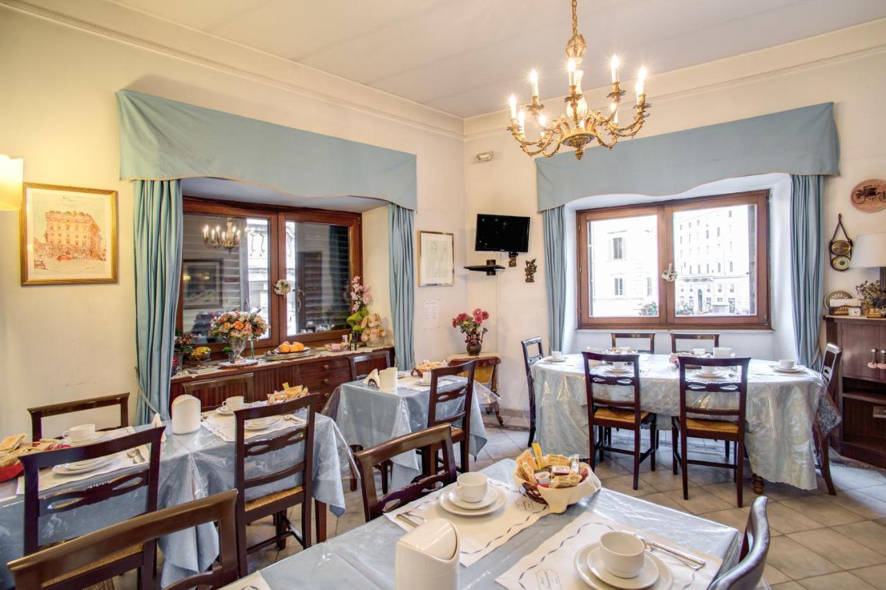 een restaurant met tafels en stoelen en een kroonluchter bij Hotel Primavera in Rome