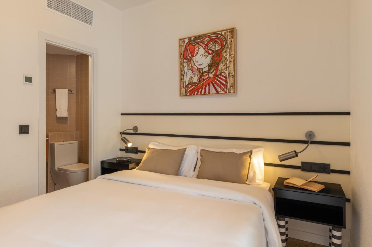 een slaapkamer met een wit bed en een schilderij aan de muur bij Hotel Robson - Smart Hotel in Lloret de Mar