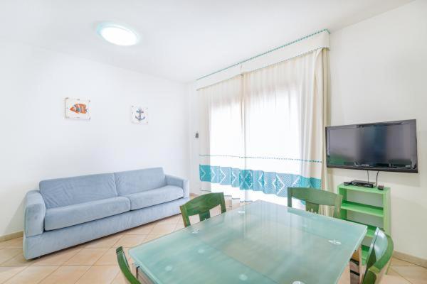een woonkamer met een bank en een glazen tafel bij Sardinia Blu Residence in Golfo Aranci
