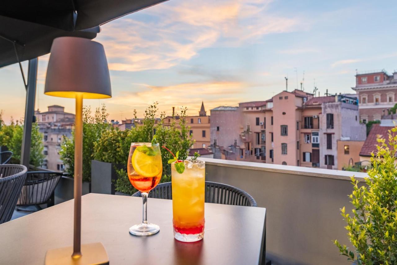 een tafel met twee drankjes op een balkon met uitzicht bij Hotel Raffaello - Sure Hotel Collection by Best Western in Ro