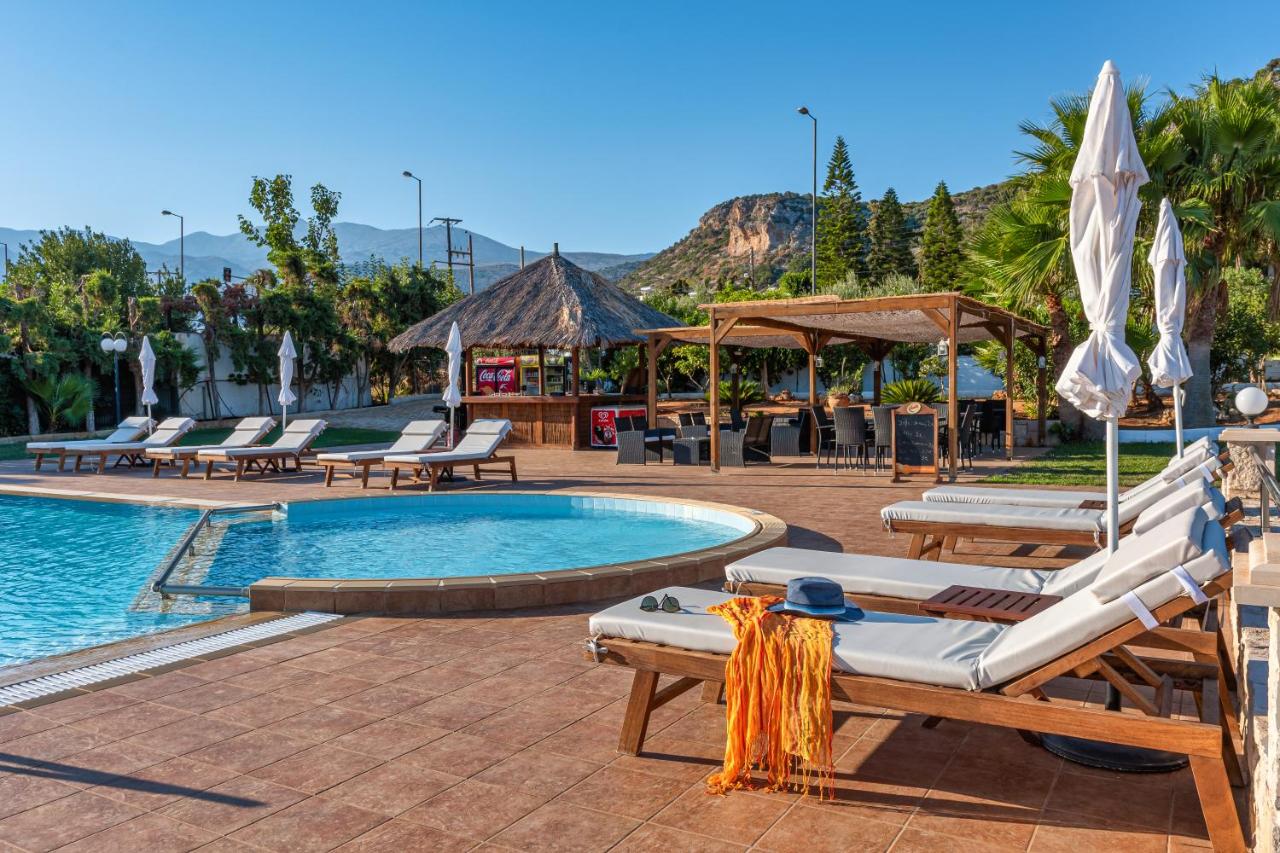 een zwembad van het resort met ligstoelen en een tafel. bij W Suites by Estia in Stalida