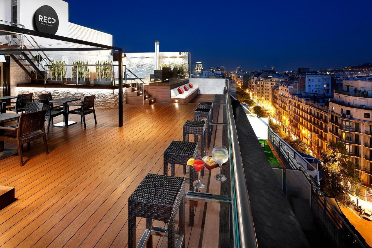 een balkon met tafels en stoelen aan een gebouw bij HCC Regente in Barcelona