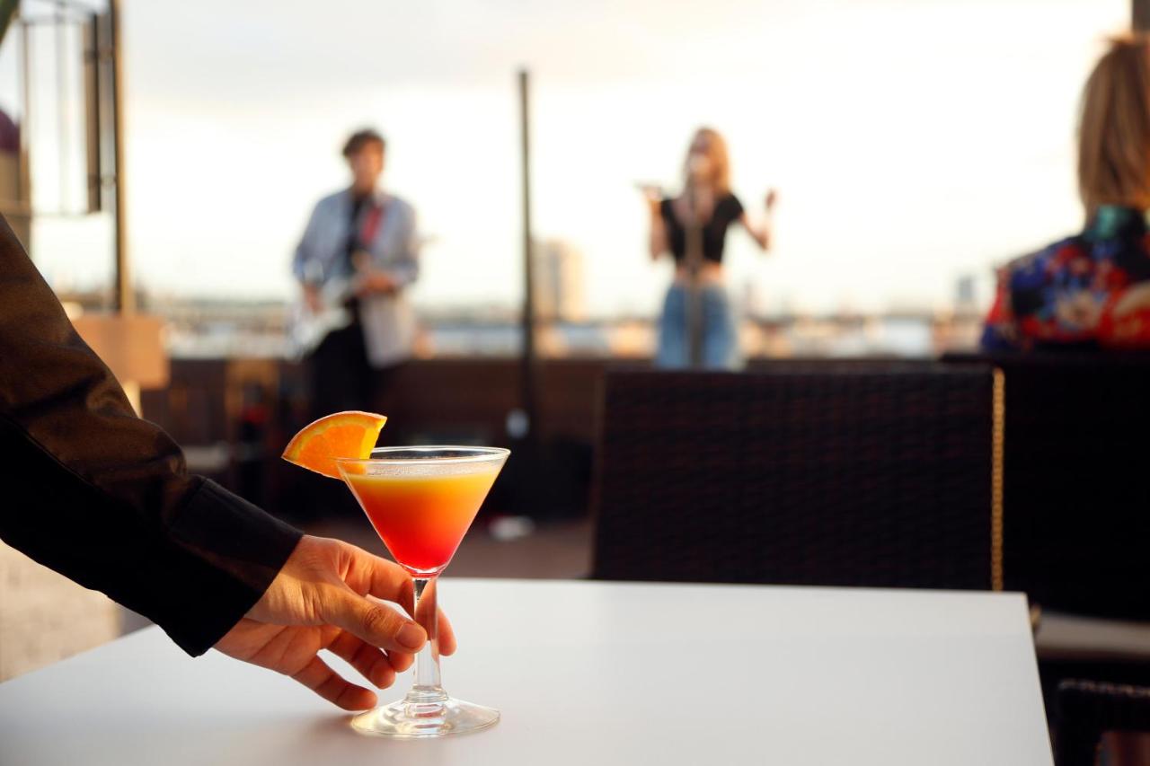 een persoon die een drankje op een tafel vasthoudt bij HCC Regente in Barcelona