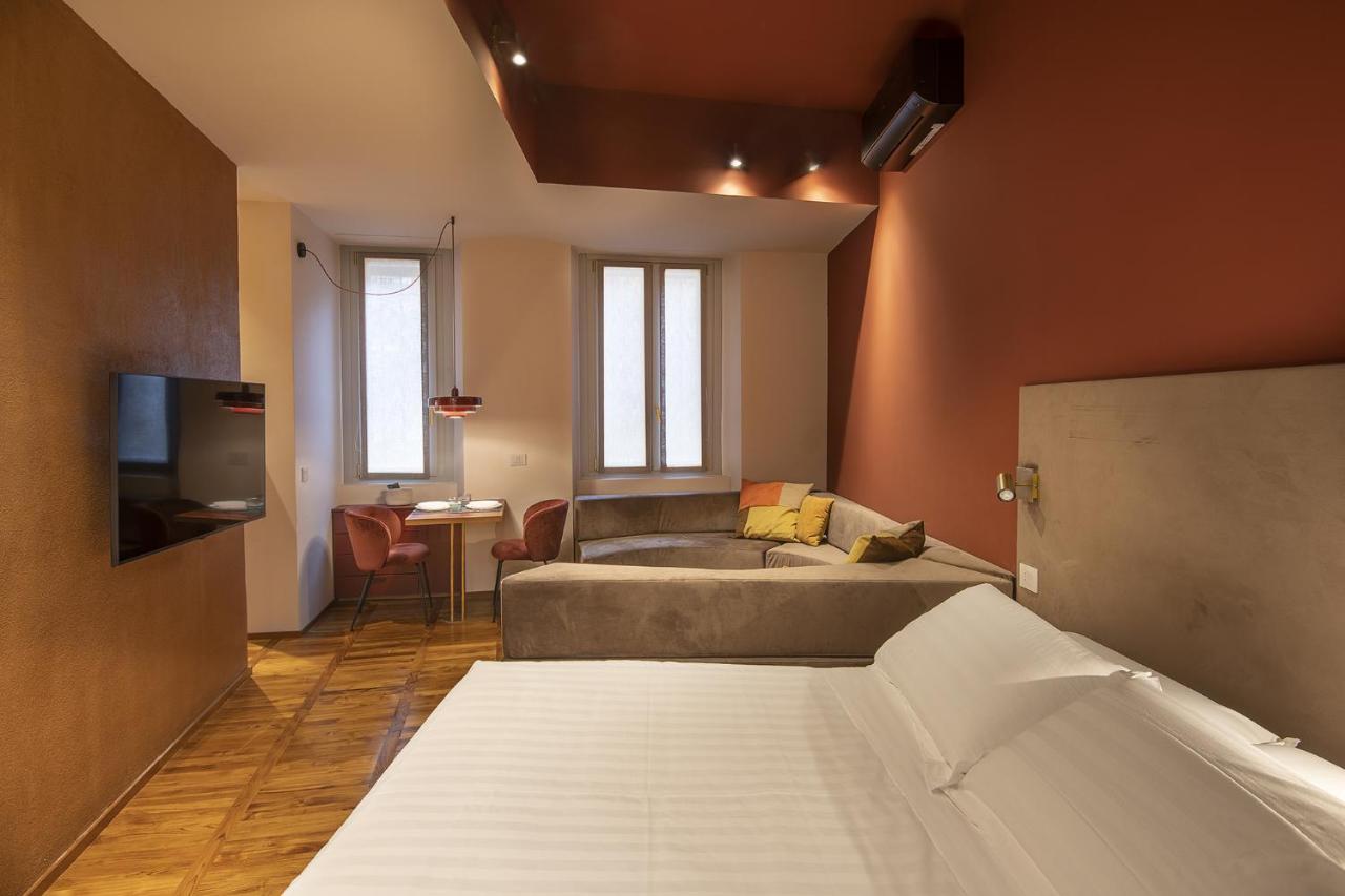 een slaapkamer met een bed, een tv en een badkuip bij Fifty Eight Suite Milan Regina Margherita in Milaan