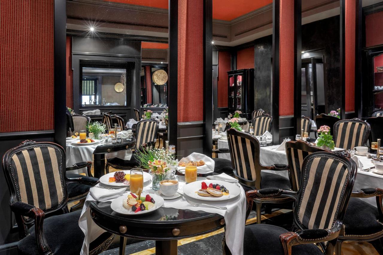een restaurant met tafels en stoelen waarop eten staat bij Baglioni Hotel Regina - The Leading Hotels of the World in Ro