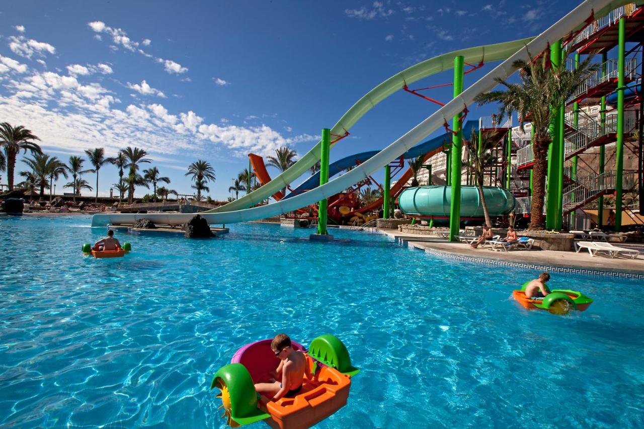 een groep mensen die op vlotten in het water van een waterpark varen bij Hotel LIVVO Valle Taurito & Aquapark in Taurito