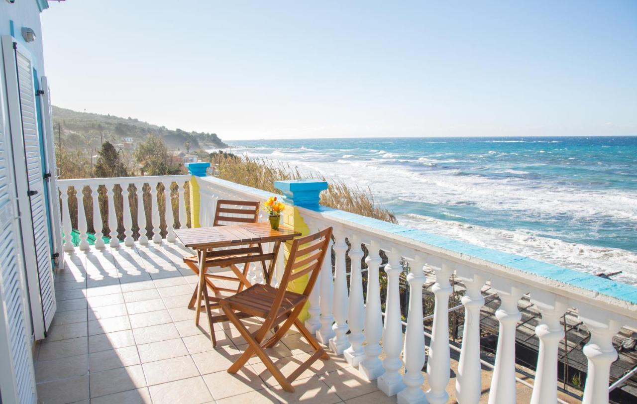 een balkon met een tafel en stoelen en uitzicht op de oceaan bij Margarita & Filippos Apartments Corfu in Paramonas