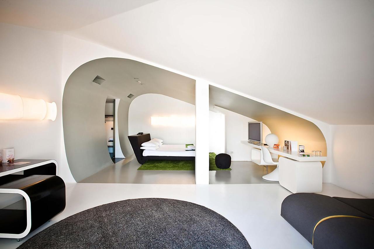 een witte kamer met een bed en een spiegel bij Hotel Ripa Roma in Rome +109 foto's