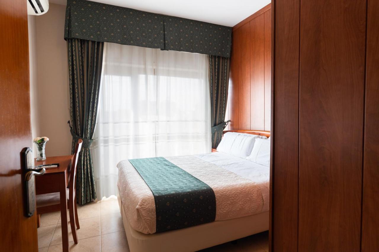 een slaapkamer met een bed voor een raam bij Hotel Alameda Málaga in Málaga