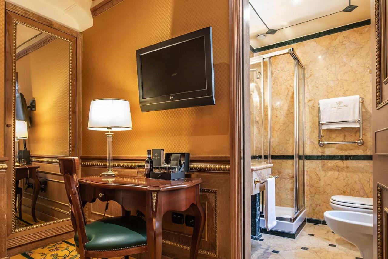 een badkamer met een bureau met een televisie en een toilet. bij River Palace Hotel in Rome