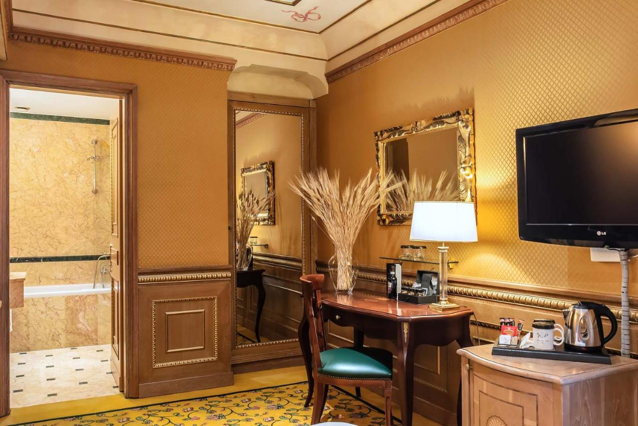 een hotelkamer met een bureau en een televisie bij River Palace Hotel in Rome