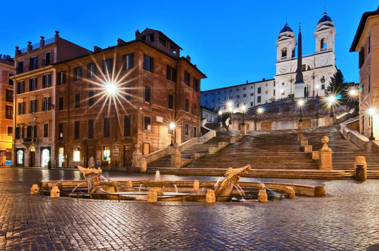een stadsplein met trappen en gebouwen 's nachts bij River Palace Hotel in Rome
