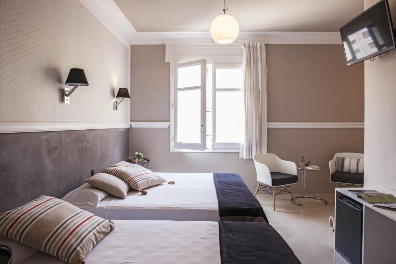 een hotelkamer met twee bedden en een raam bij AinB B&B Eixample-Muntaner in Barcelona