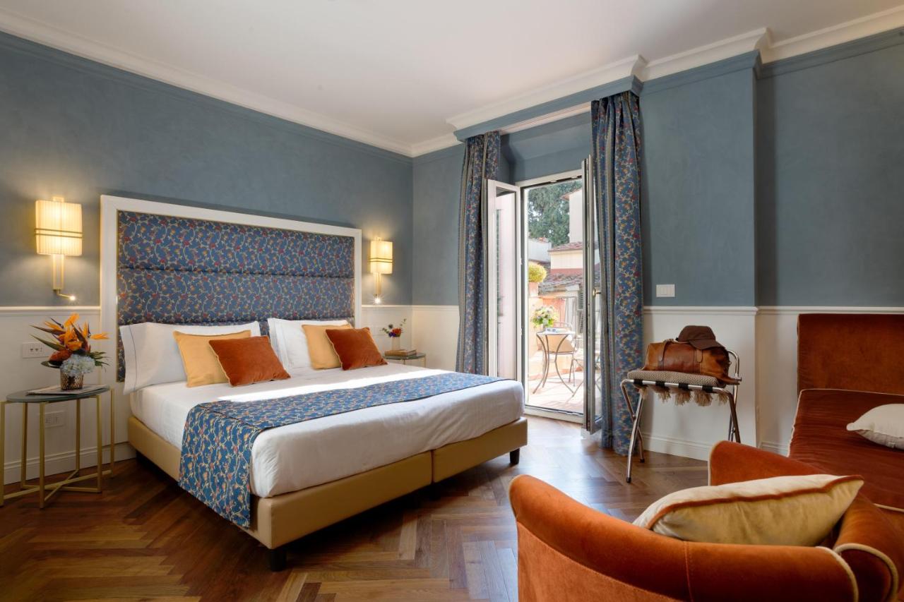 een slaapkamer met een groot bed en blauwe muren bij Rivoli Boutique Hotel in Florence