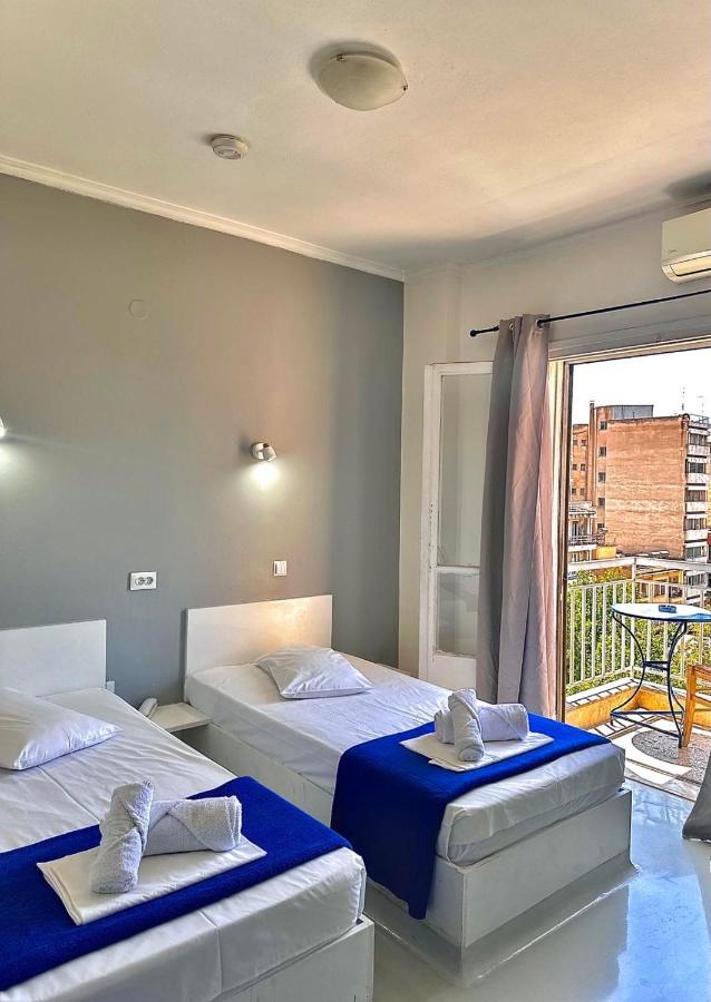 twee bedden in een kamer met balkon bij Sparta Team Hotel in Athene