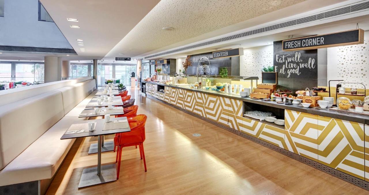 een restaurant met een lange toonbank met tafels en stoelen bij Sercotel Hotel Rosellon in Barcelona