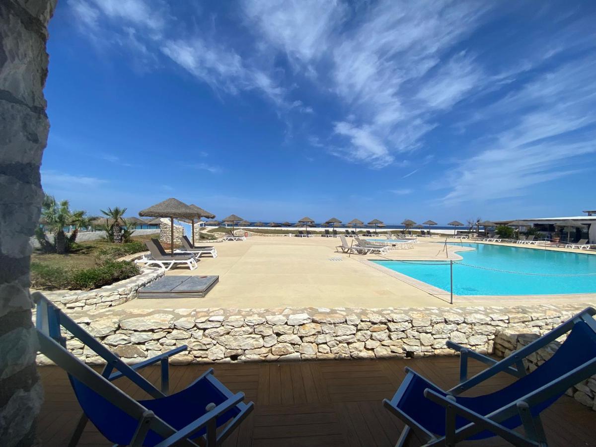 een paar blauwe stoelen en een zwembad bij Baia dei Mulini Resort & Spa in Trapani