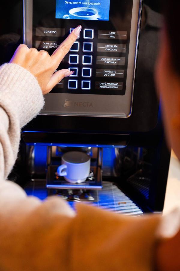 een vrouw typt op haar telefoon in een magnetron bij CAVALLO Hotel Noventa di Piave in Noventa di Piave