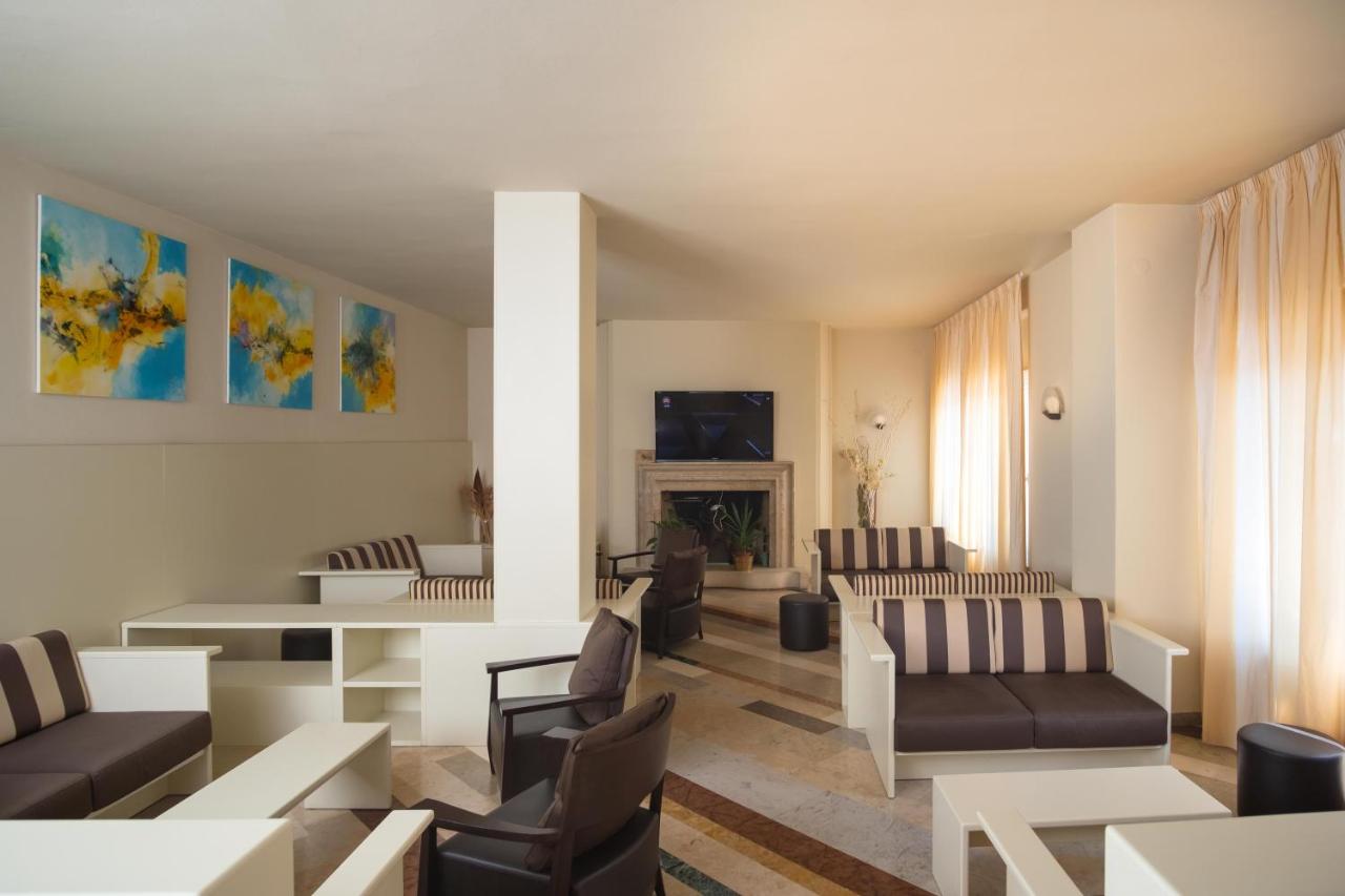 een woonkamer met banken en een open haard bij Hotel Romeo in Torri del Benaco