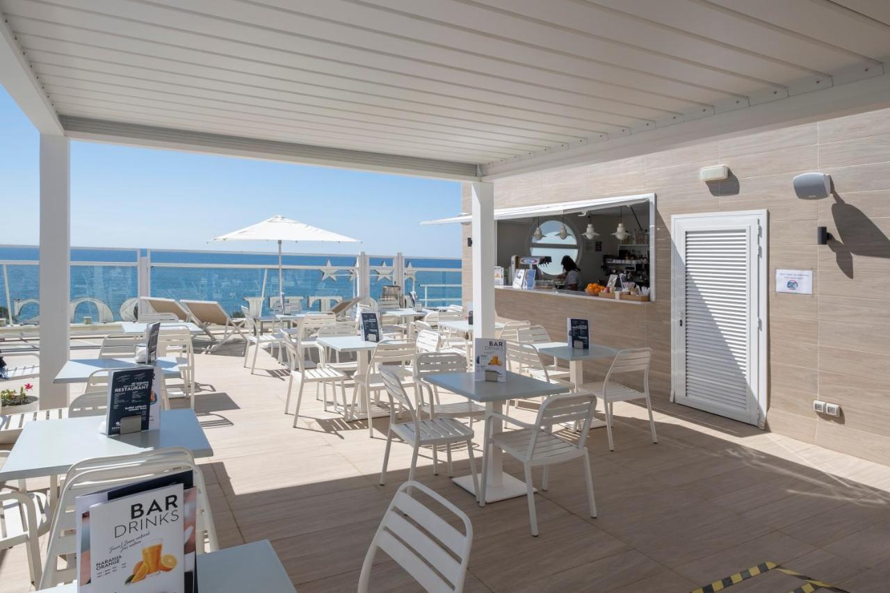 een restaurant met tafels en stoelen op een balkon bij Rosamar Maritim 4* in Lloret de Mar