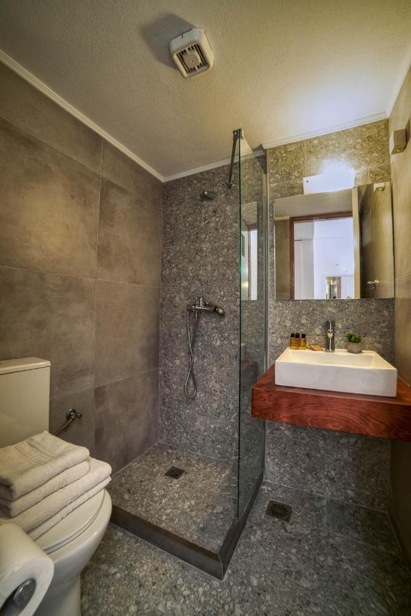 een badkamer met een douche, een wastafel en een toilet. bij Roxani Hotel in Amoudara Herakliou